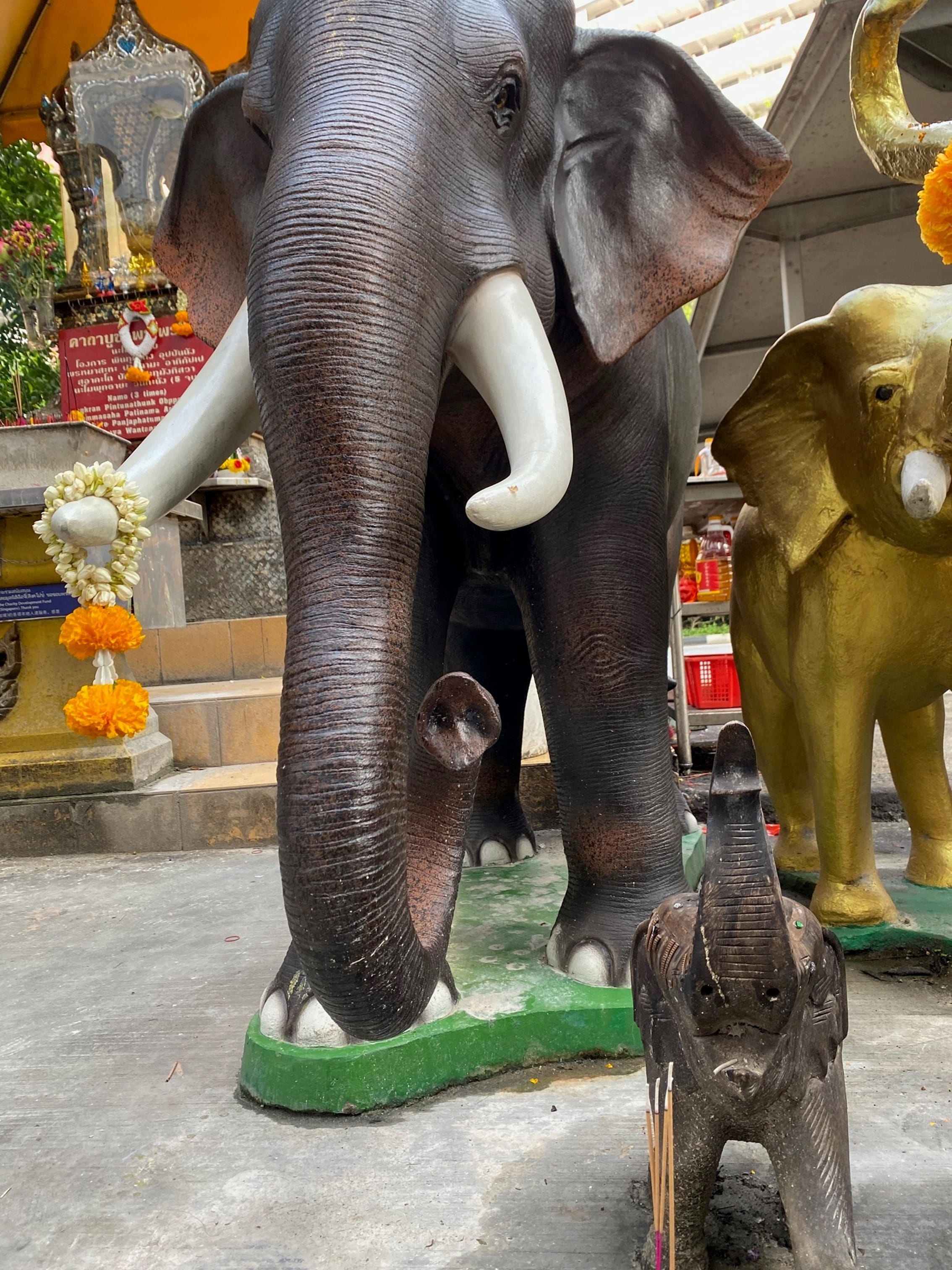 Animal statues stand guard in front of the statue of Phra Phrom, 2022.